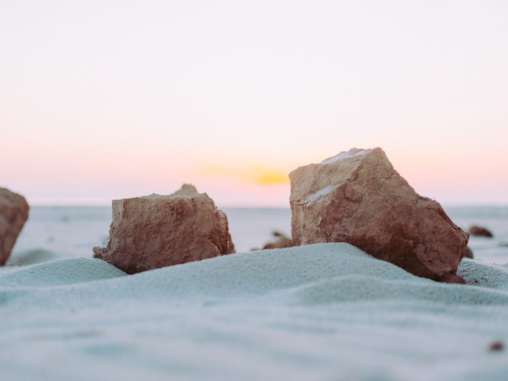 夕日と砂浜と石